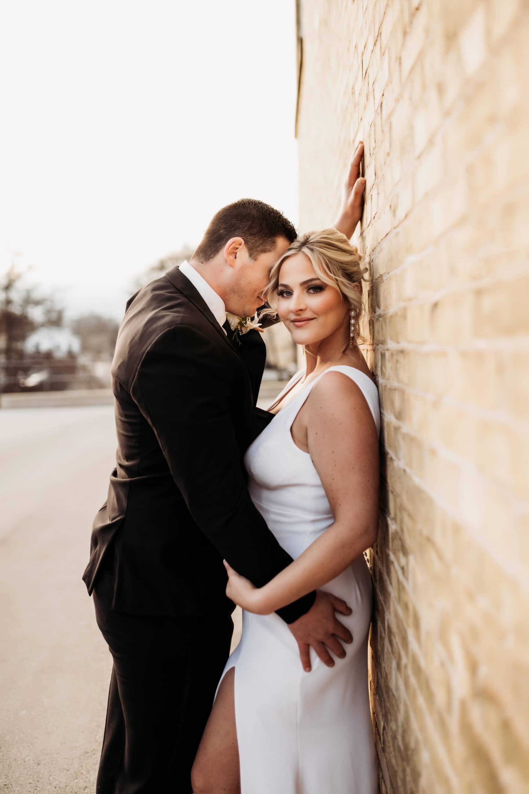 Wedding & Elopement Photography, Groom leaning over bride with his hand on the wall behind her