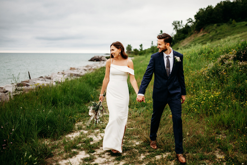 Wedding & Elopement Photography, bride and groom walking on cliffside near the ocean