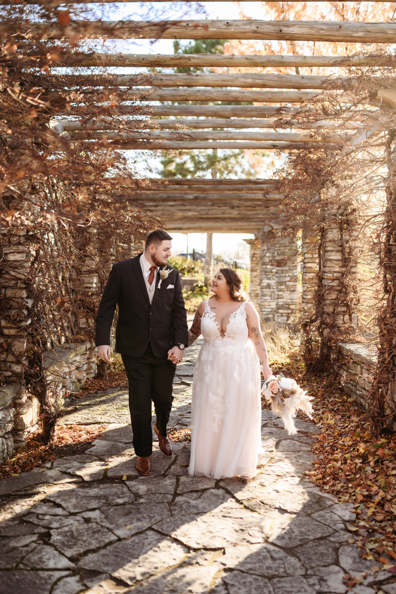 Wedding & Elopement Photography, bride and groom walking under an outdoor patio
