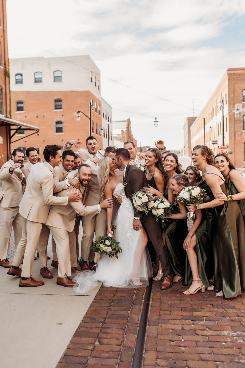 Wedding & Elopement Photography, bride and groom kissing surrounded by a large bridal party